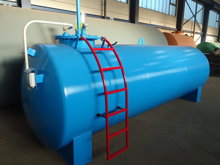 Blauer Tank mit roter Leiter, in einer Lagerhalle aufgestellt.