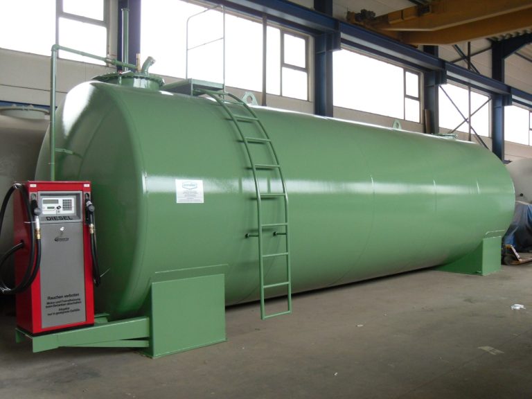 Grüner Dieseltank mit Leiter und Pumpenstation in einer Industrieumgebung.