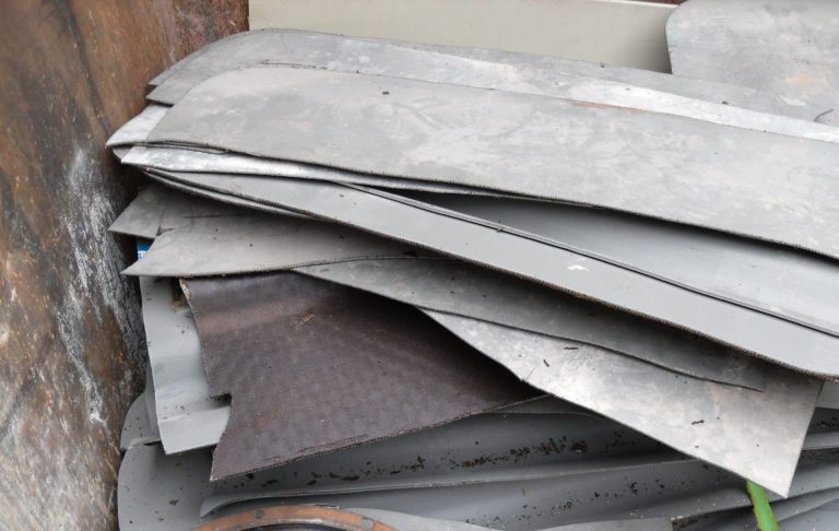 Haufen aus verschiedenen Metallplatten und Blechstücken in grauen Farbtönen, ausgebauter Heizöltank