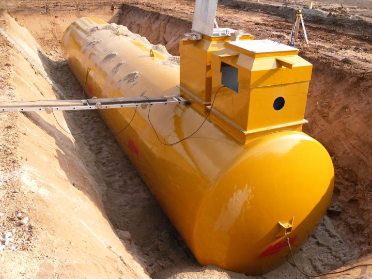 Gelber, unterirdischer Tank in einer Baugrube, teilweise eingegraben.
